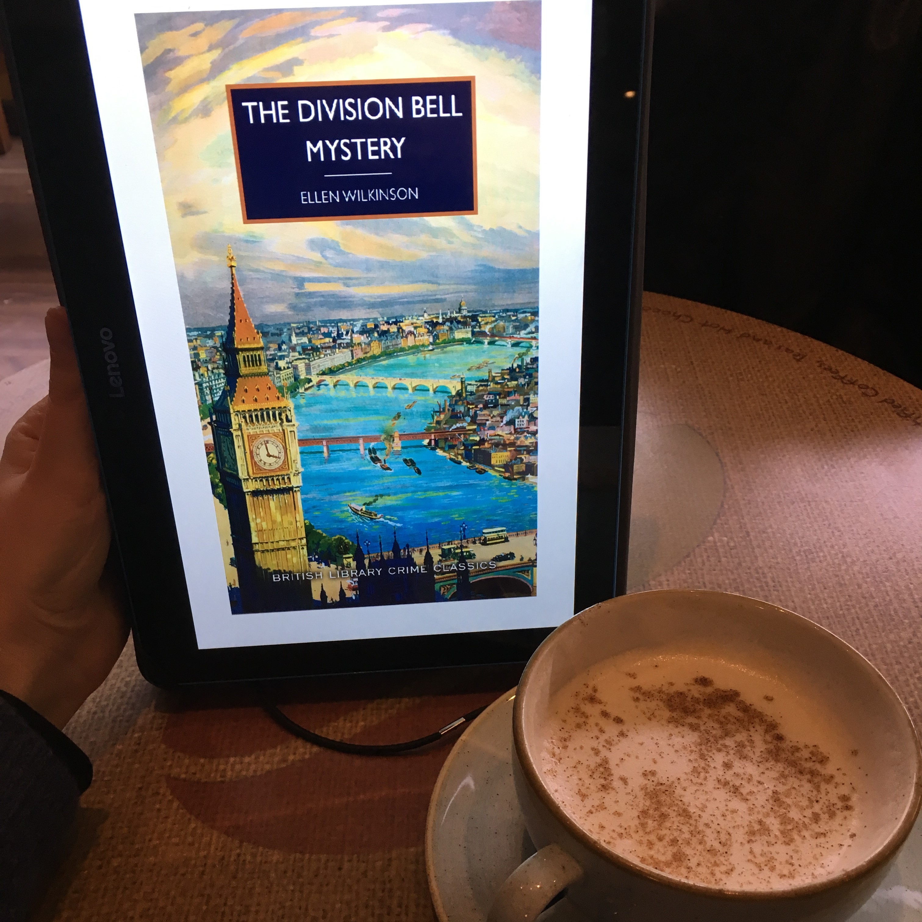 Tablet showing 'The Division Bell Mystery', near a chai latte
