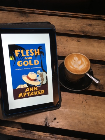 Tablet showing 'Flesh and Gold' by Ann Aptaker, next to a latte in a glass